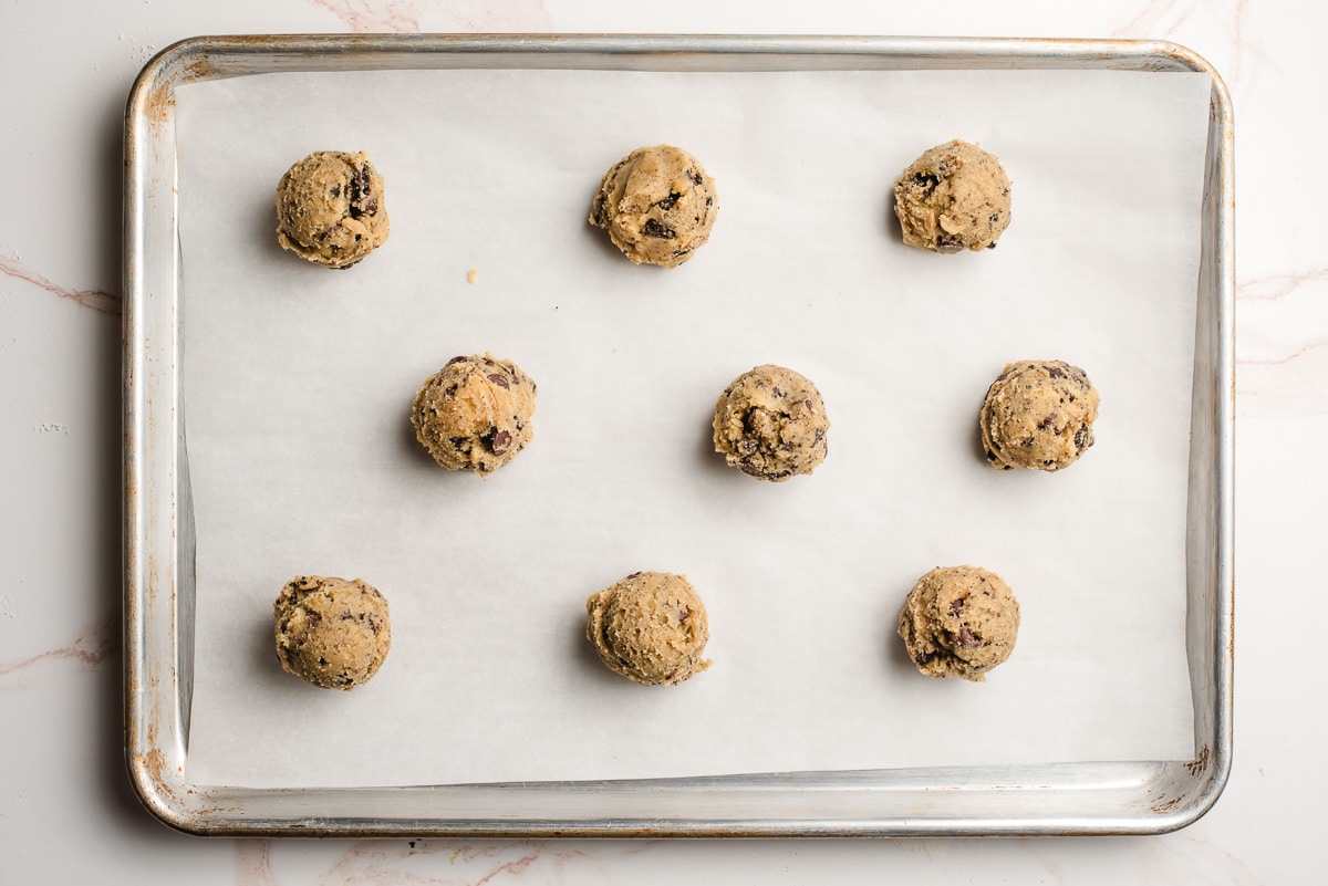 Mint Oreo Cookie dough balls on a parchment lined baking sheet.