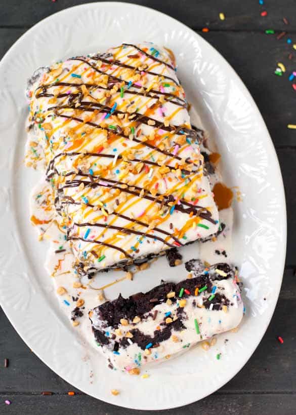 Layers of brownie and ice cream covered in sprinkles, chocolate, and caramel syrup. A sundae in cake form!