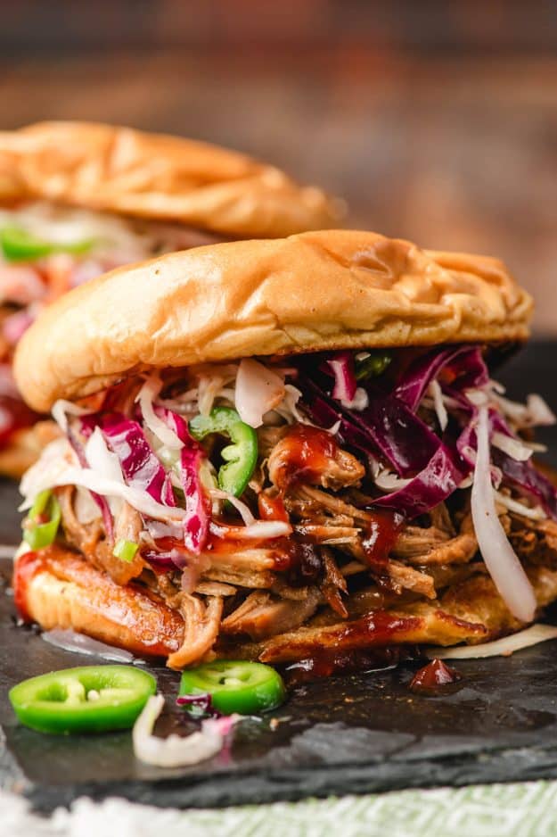 Spicy pulled pork sandwich loaded with coleslaw and BBQ sauce.