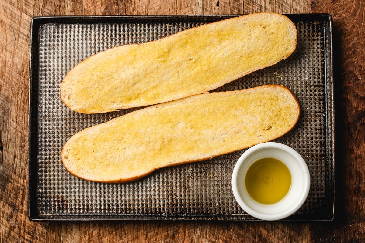 Halved French bread loaf brushed with olive oil.