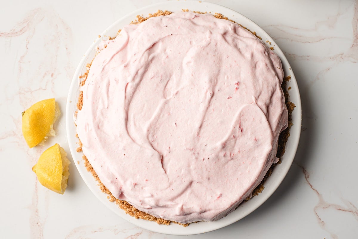 Strawberry lemonade filling stacked into a graham cracker pie crust.