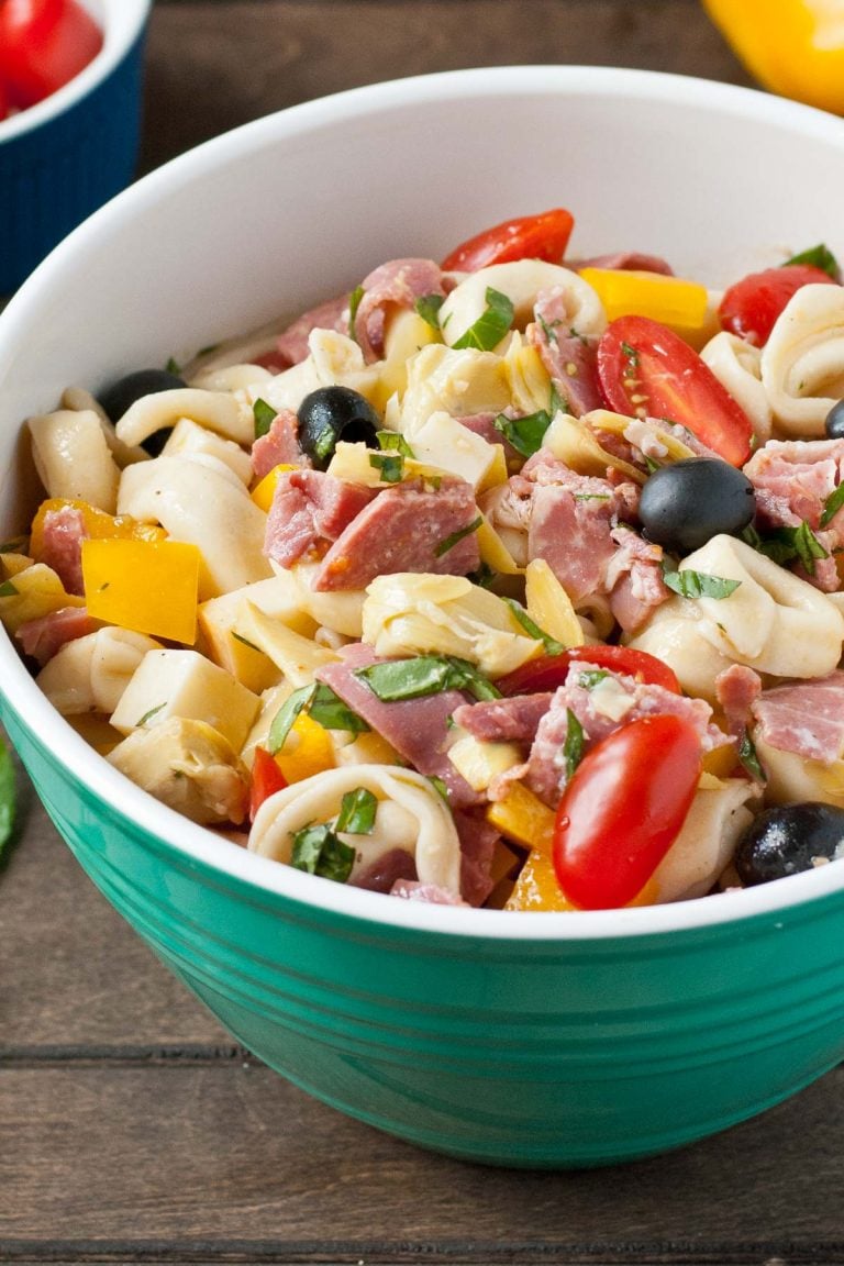 Tortellini pasta salad with cured meats, tomatoes, artichokes, and olives.