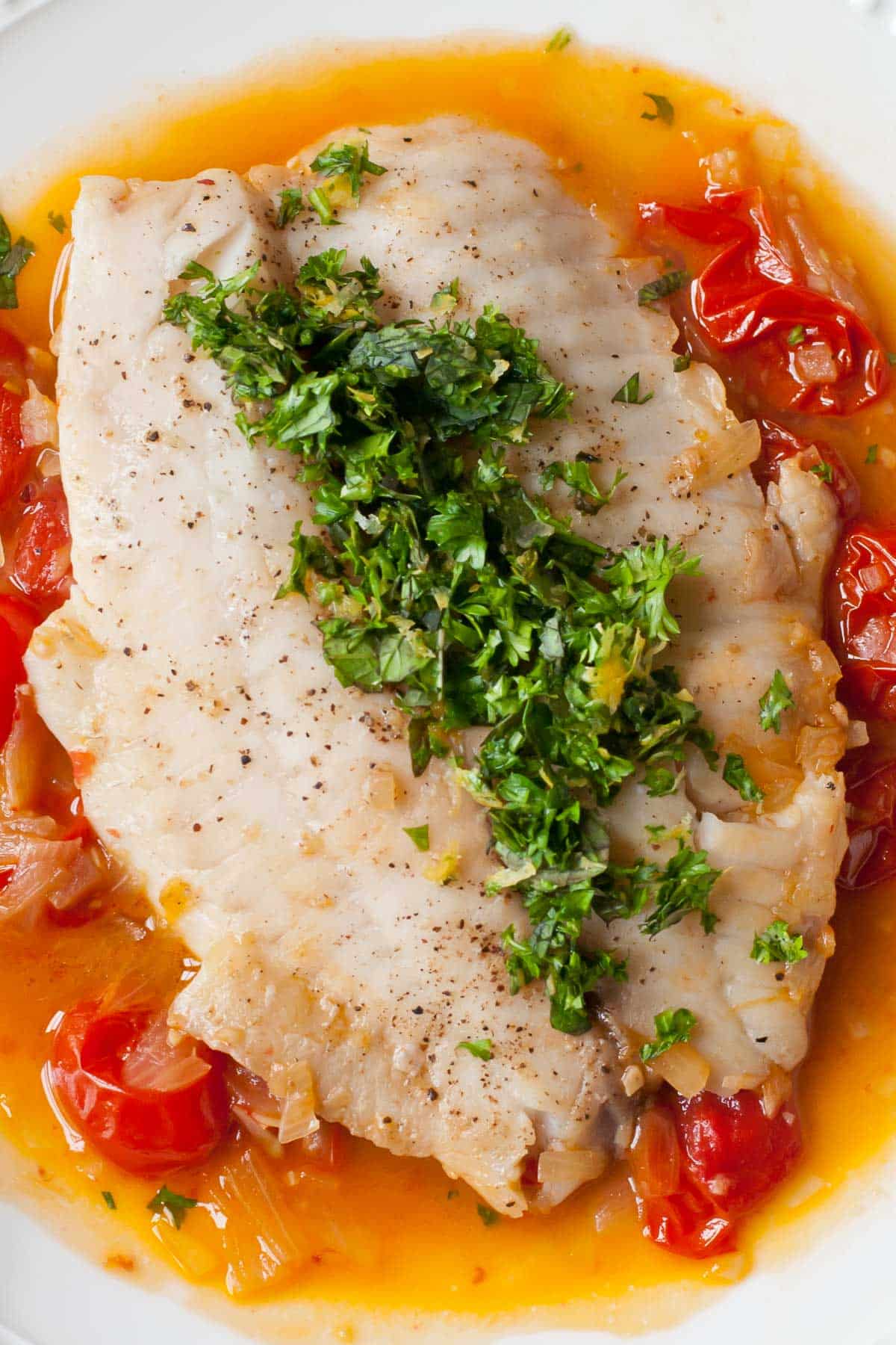Tilapia filet poached in tomato broth with fresh parsley and mint.