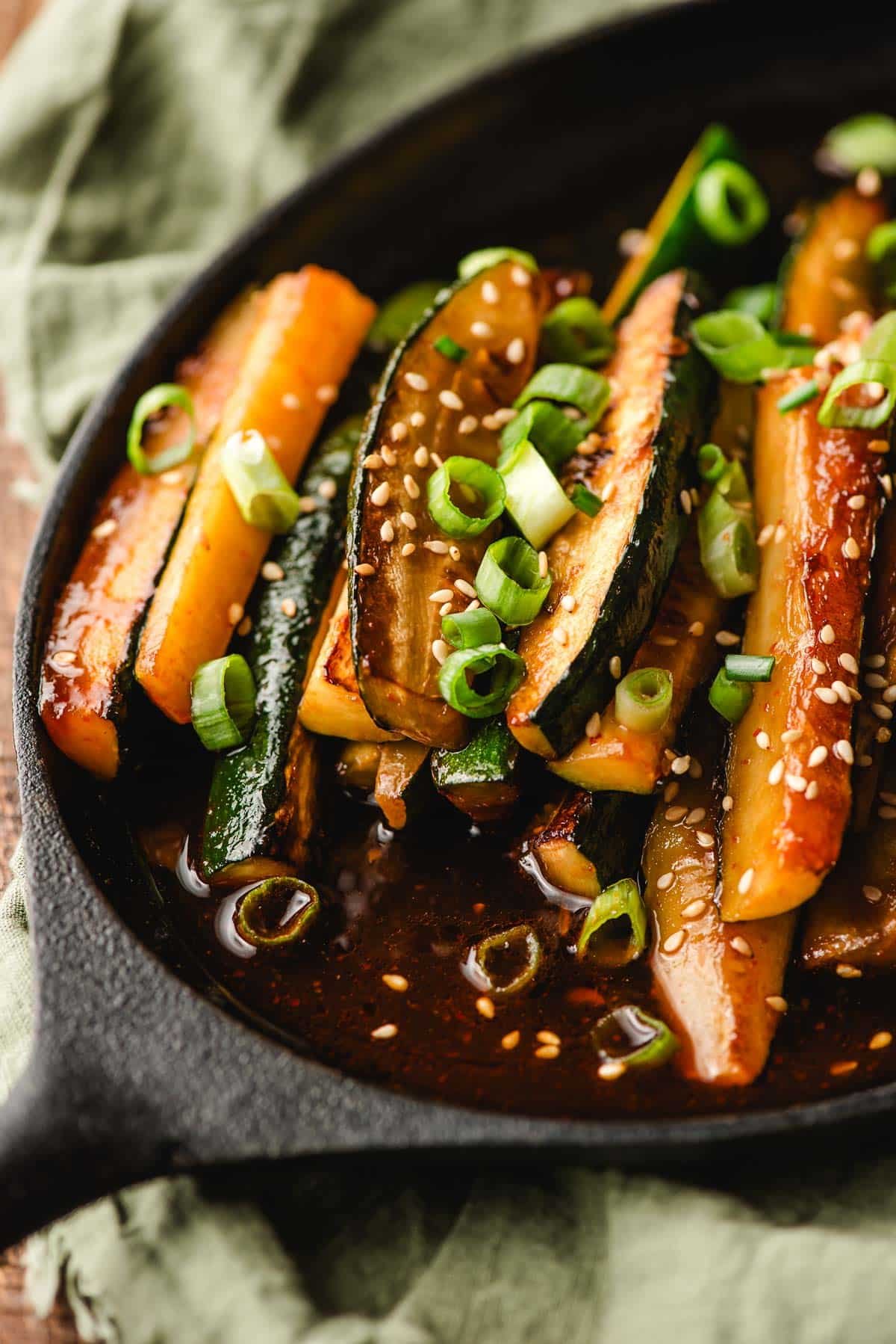 Spicy chinese zucchini with sriracha on a cast iron platter.