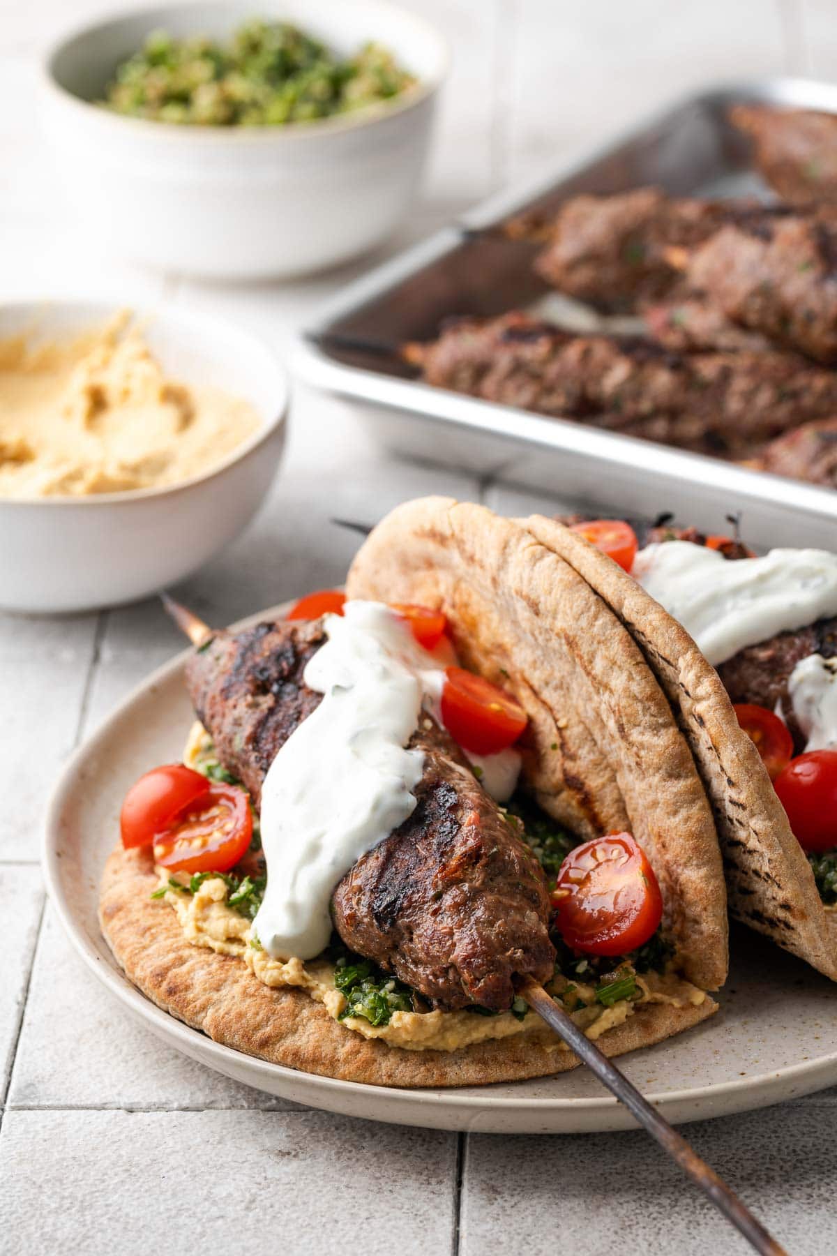 Ground beef kafta in a pita with tzatziki sauce and cherry tomatoes.