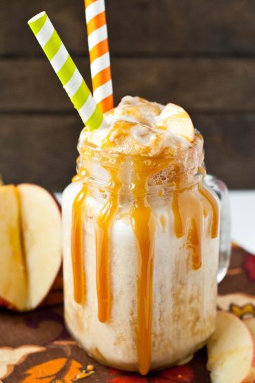 Glass mug with ice cream, apple cider, ginger ale, and caramel sauce drizzled on the outside.
