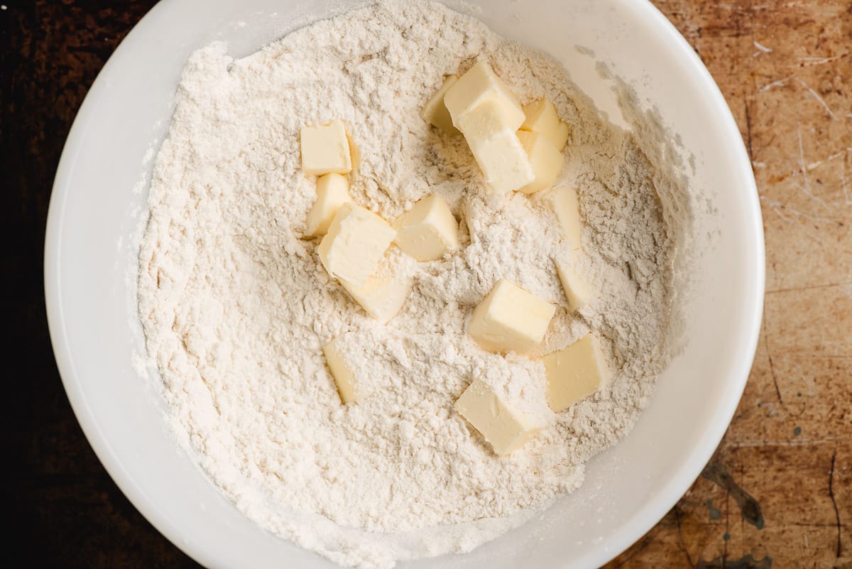 Cubes of butter in a bowl with flour, sugar, salt, and baking powder.