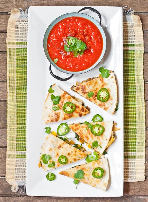 a plate of vegetarian quesadillas with a bowl of salsa