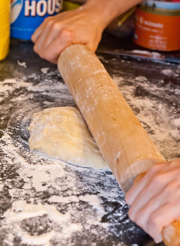 butterhorn dough is rolled with a rolling pin and flour