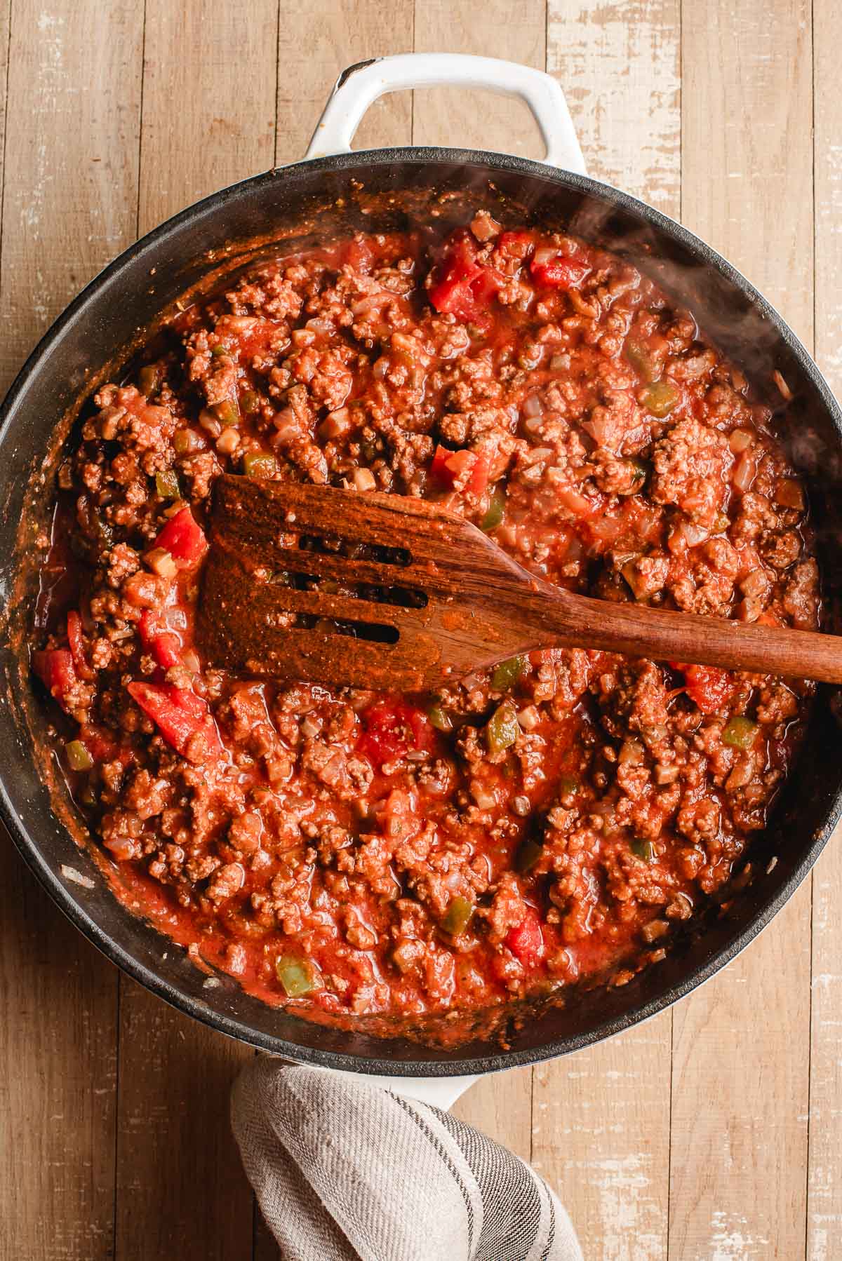 Ground beef and veggies with tomato sauce and seasonings in a large skillet.