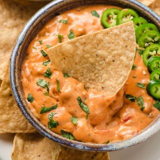 Chip dipped into a bowl of velveeta sausage cheese dip.