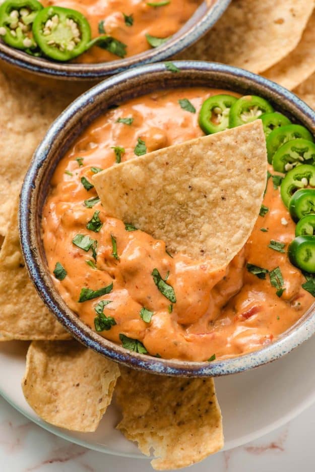 Chip dipped into a bowl of velveeta sausage cheese dip.