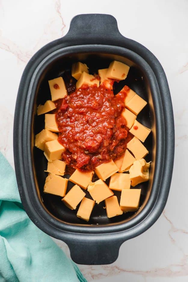 Cubed velveeta and salsa in a slow cooker.
