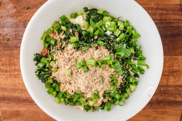 Green onions, knorr vegetable mix, spinach, sour cream, mayonnaise, and lemon juice in a mixing bowl.