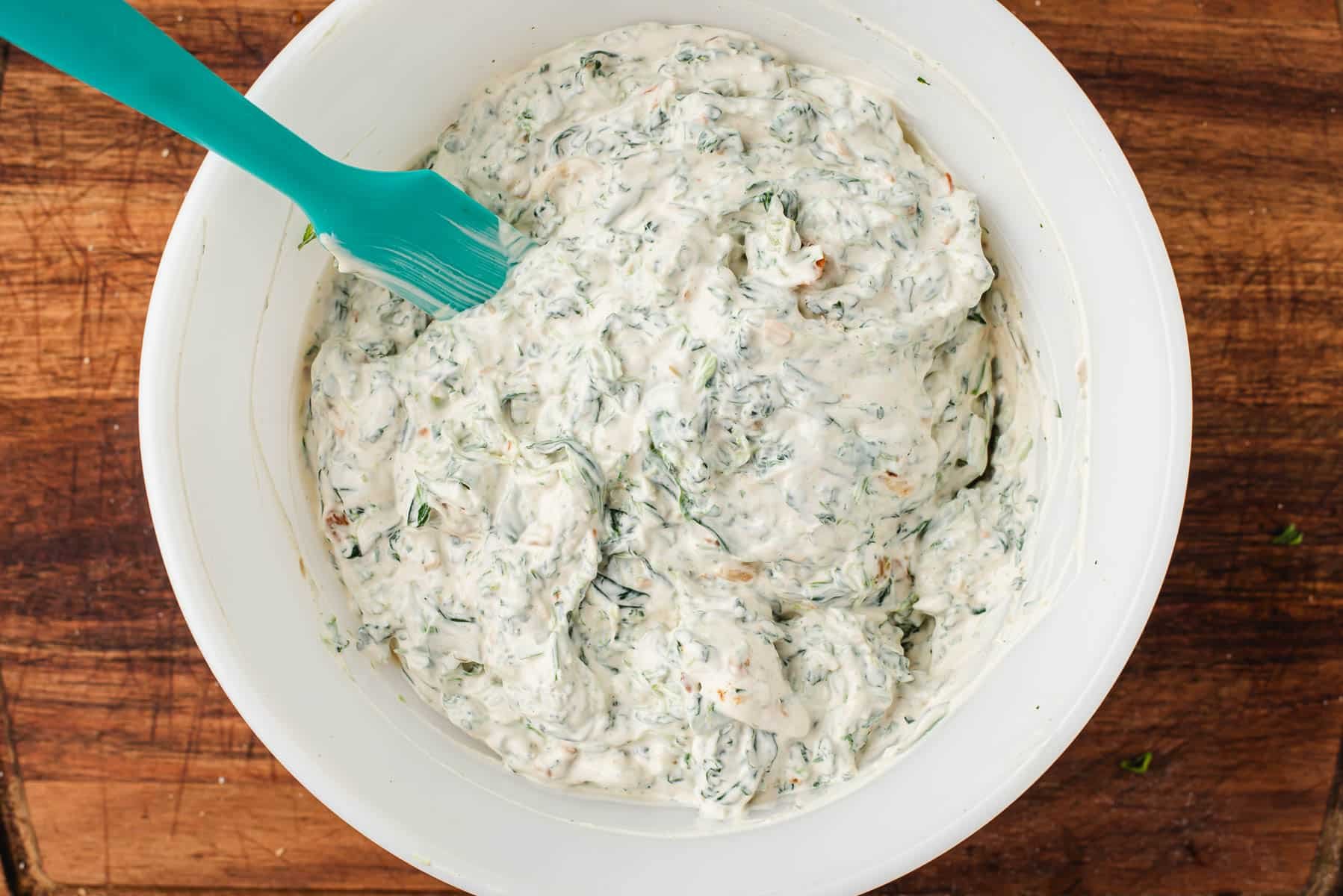 Knorr Spinach Dip recipe in a mixing bowl with a spatula.