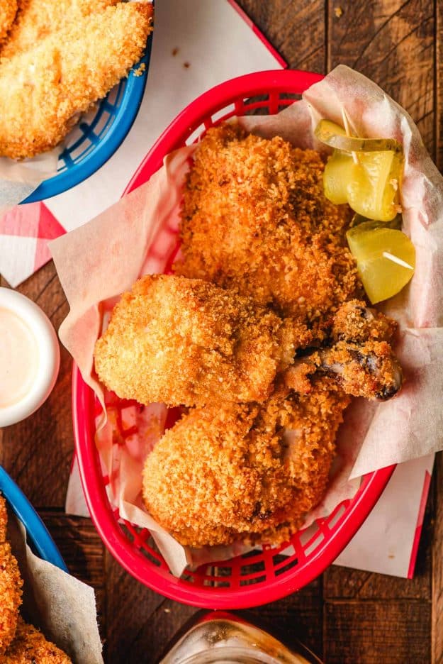 Basket of crispy oven fried chicken drumsticks and thighs.