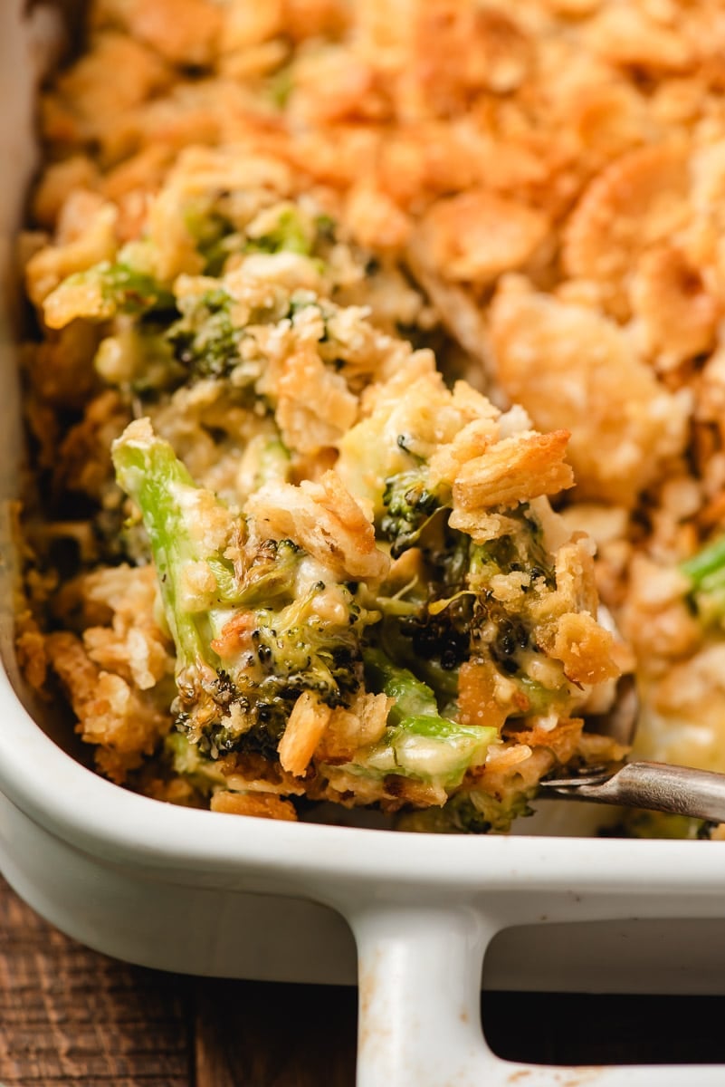 Broccoli cheese casserole with ritz cracker topping in a white casserole dish.