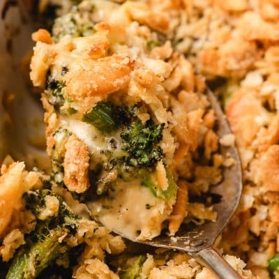 A scoop of Broccoli Ritz Casserole being lifted from the dish.