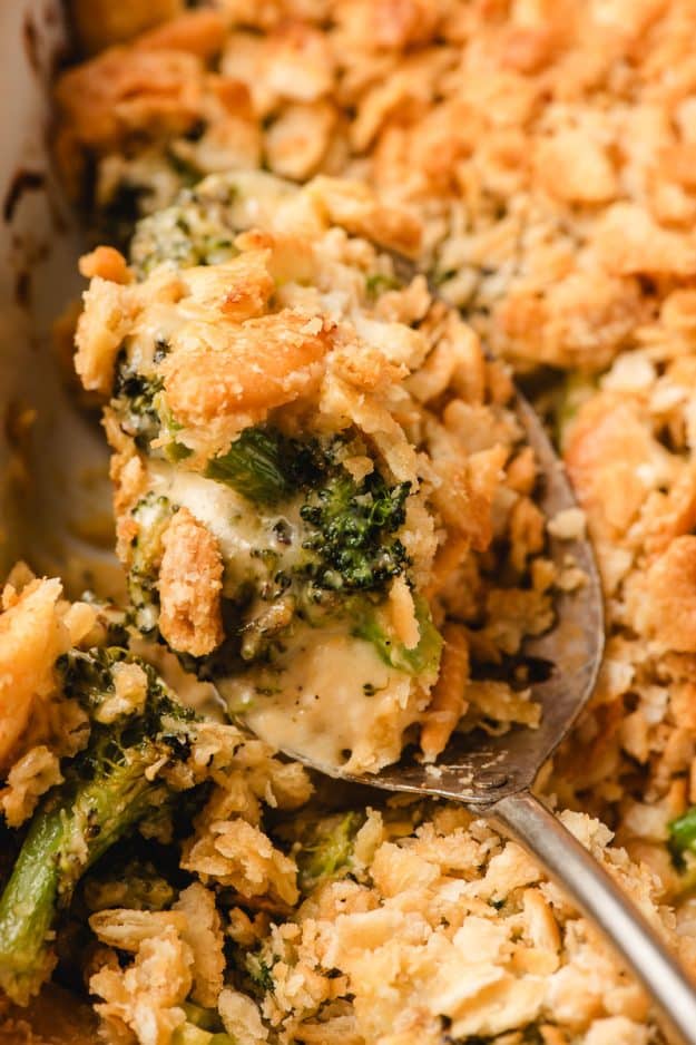A scoop of Broccoli Ritz Casserole being lifted from the dish.