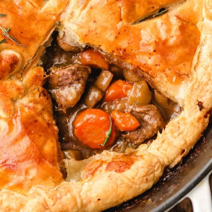 Pot pie with the crust taken off of a portion so you can see the beef and vegetable filling.