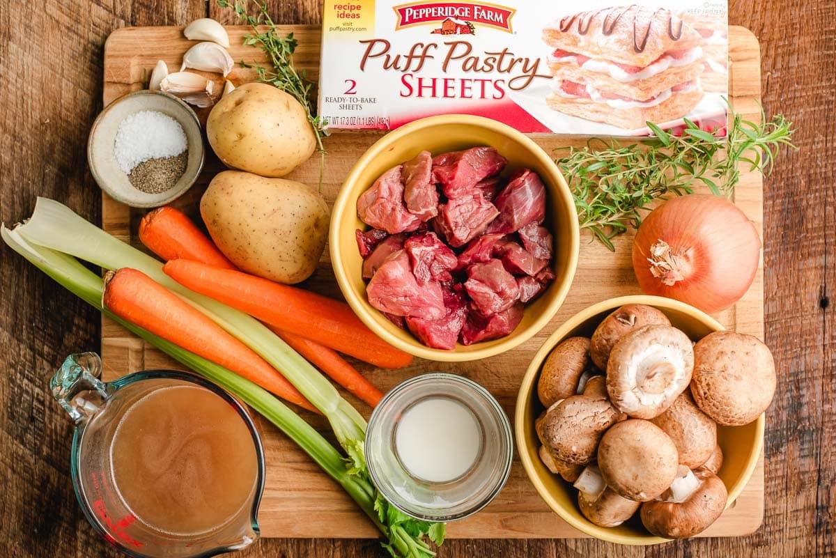 Ingredients for beef pot pie spread out on a cutting board.