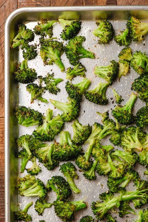 Roasted broccoli florets on a sheet pan.