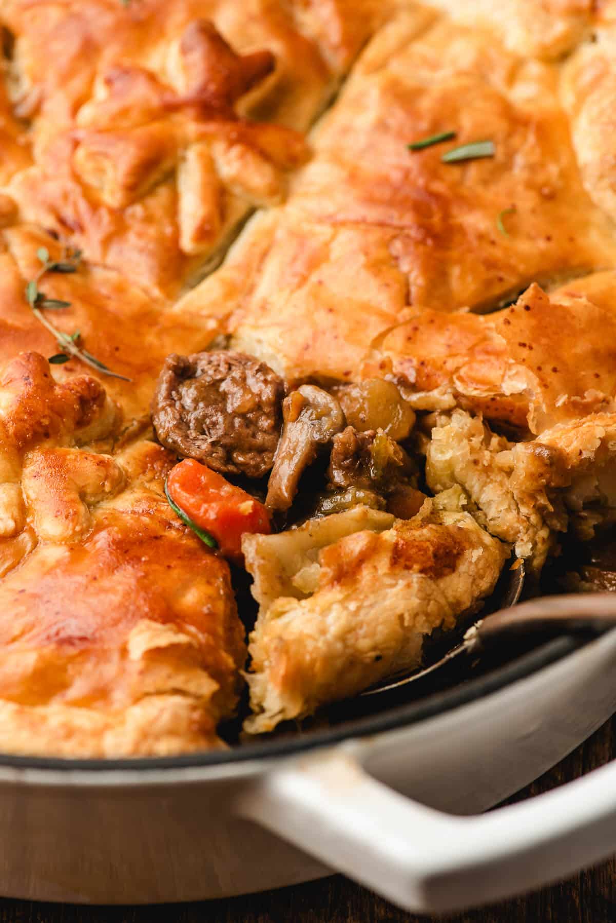 Scoop of Guinness beef pot pie with puff pastry.