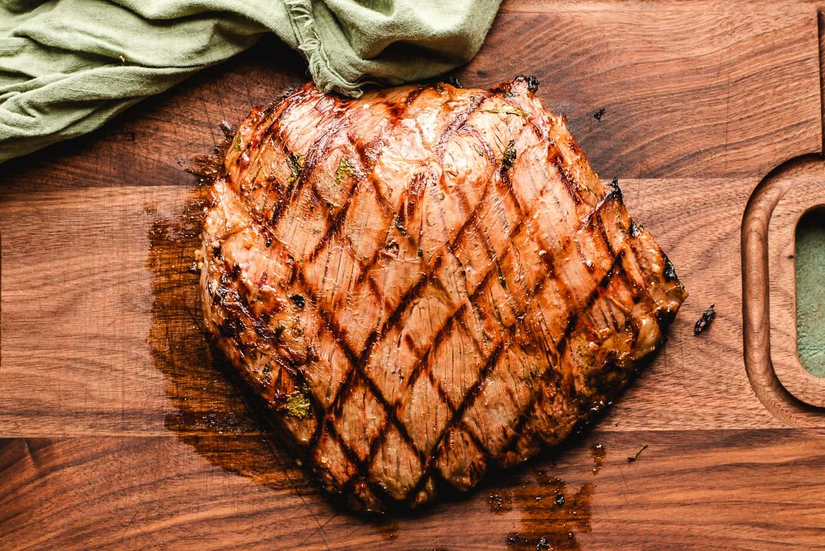 Grilled flank steak on a cutting board.