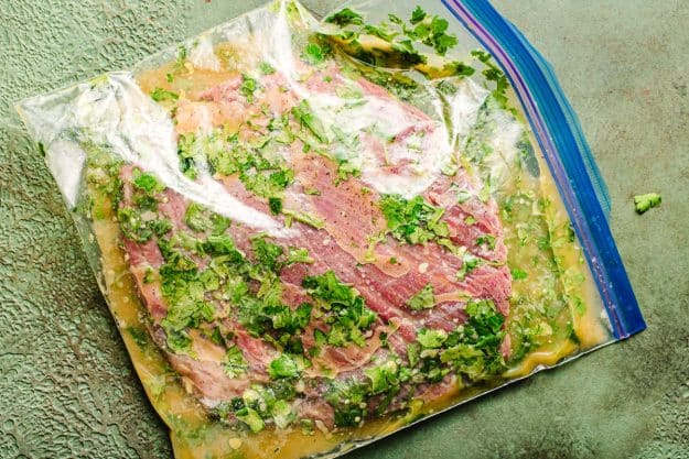 Cilantro and lime marinade for flank steak in a plastic bag.