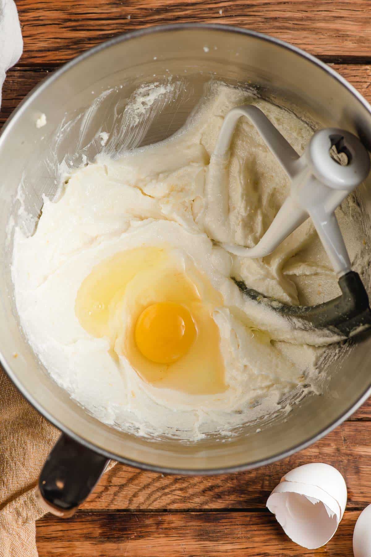 Mixing bowl with an egg, butter, and sugar.