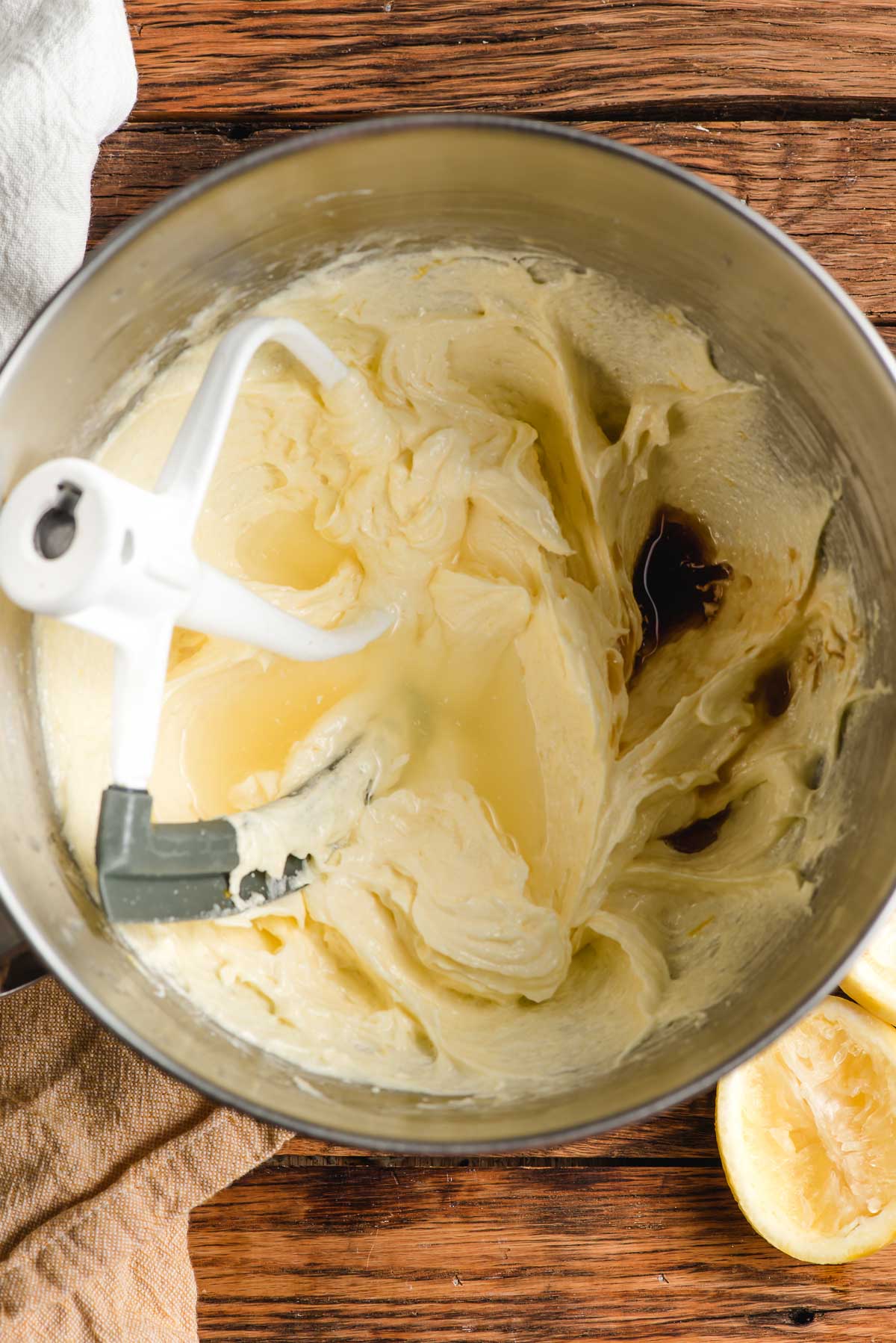 Mixing bowl showing whipped butter, sugar, eggs, lemon juice, and vanilla extract.