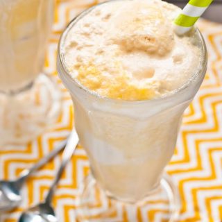 Frothy glass of an ice cream float made with orange juice and Sprite.