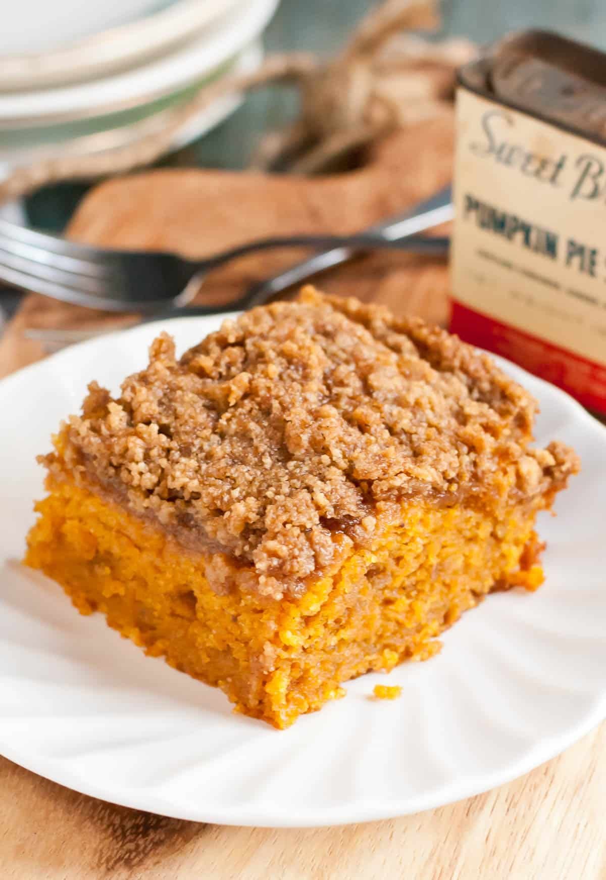 Pumpkin coffee cake with crumb topping served on a white plate.