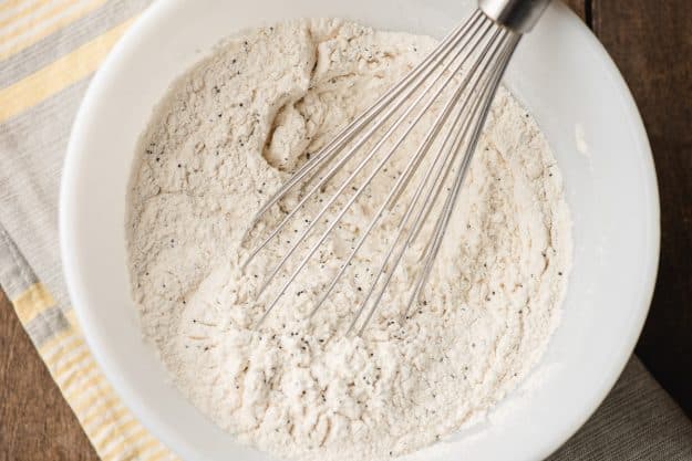 Flour, poppyseeds, baking powder, and salt whisked together in a bowl.