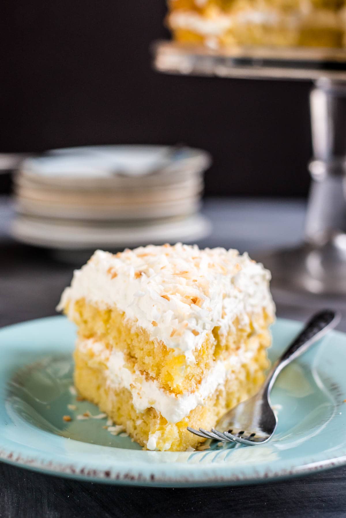 This Pineapple Coconut Cake is packed with fresh pineapple and piled high with a dreamy, fluffy whipped coconut frosting.