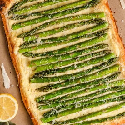 Puff pastry tart topped with ricotta, parmesan, and asparagus tart.
