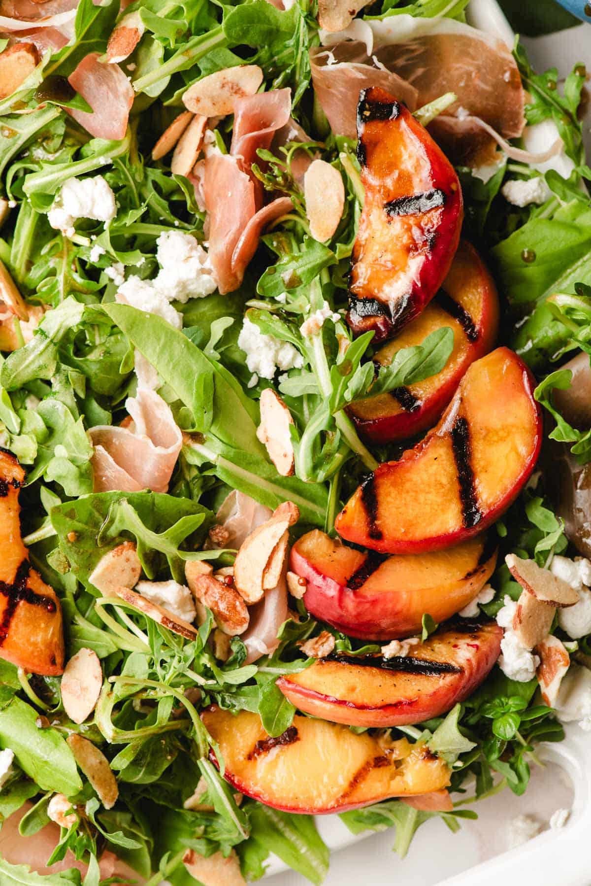 Grilled peaches on a bed of salad greens with goat cheese and prosciutto.