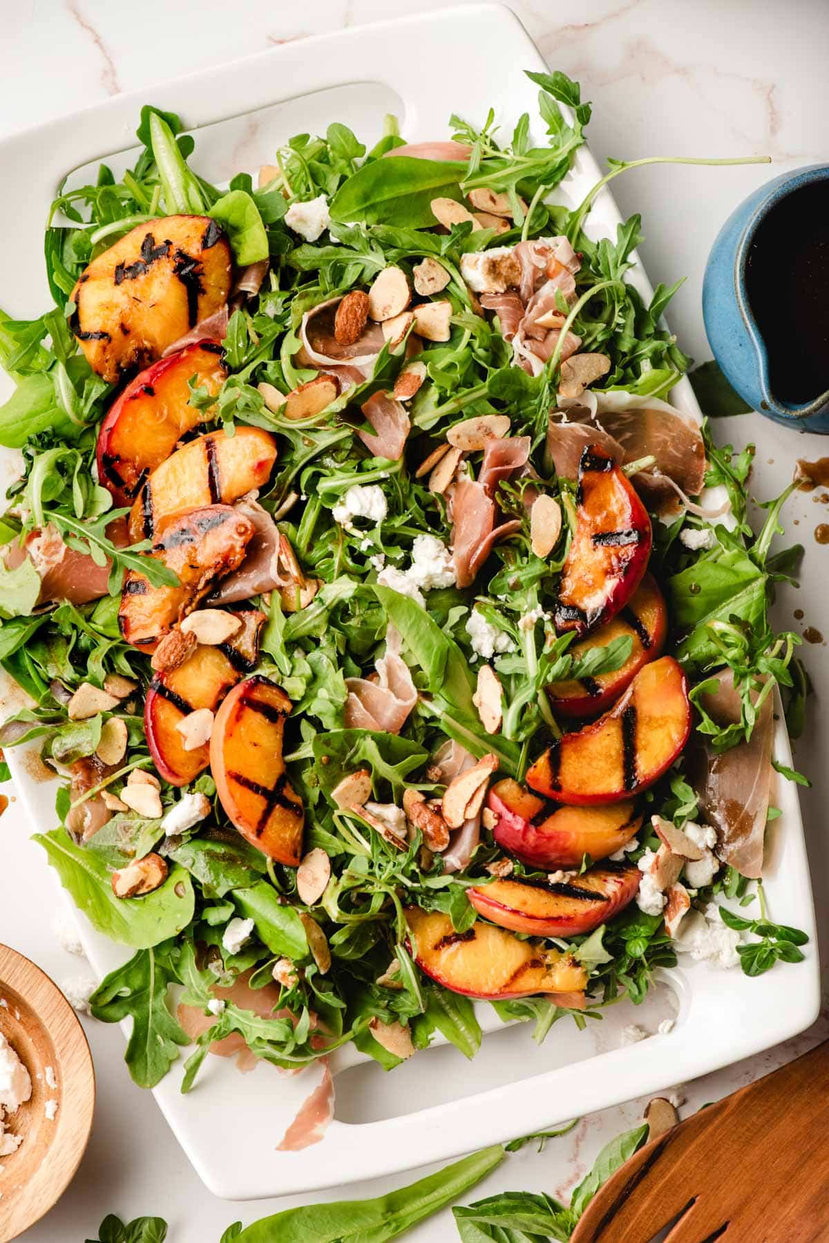 Salad platter with grilled peaches, basil, goat cheese, almonds, prosciutto, and balsamic vinaigrette.