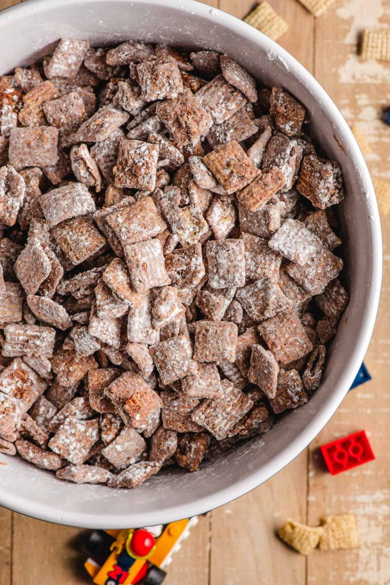 Chocolate peanut butter puppy chow in a bowl, surrounded by legos.