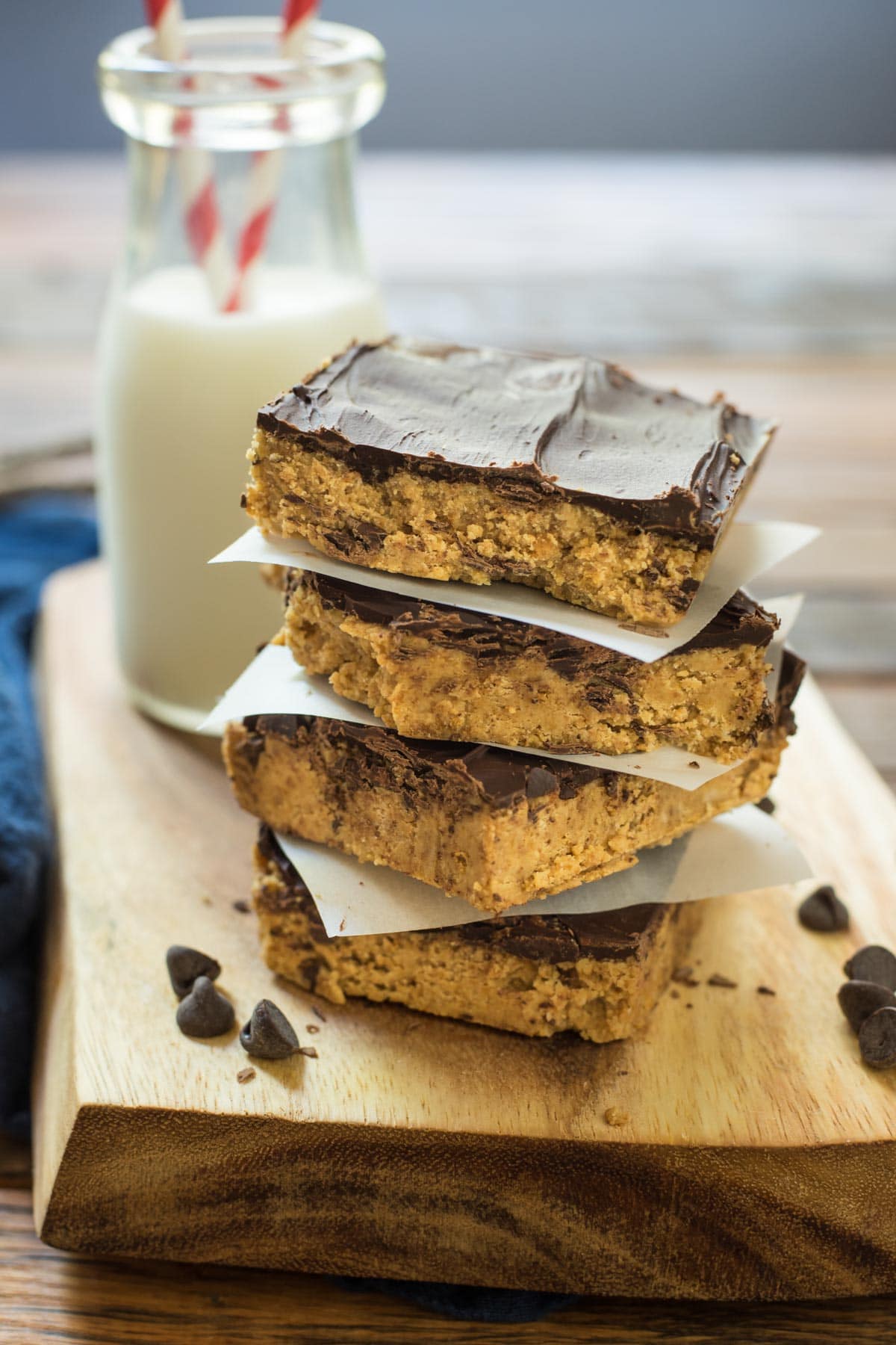 a stack of no bake peanut butter bars served with milk