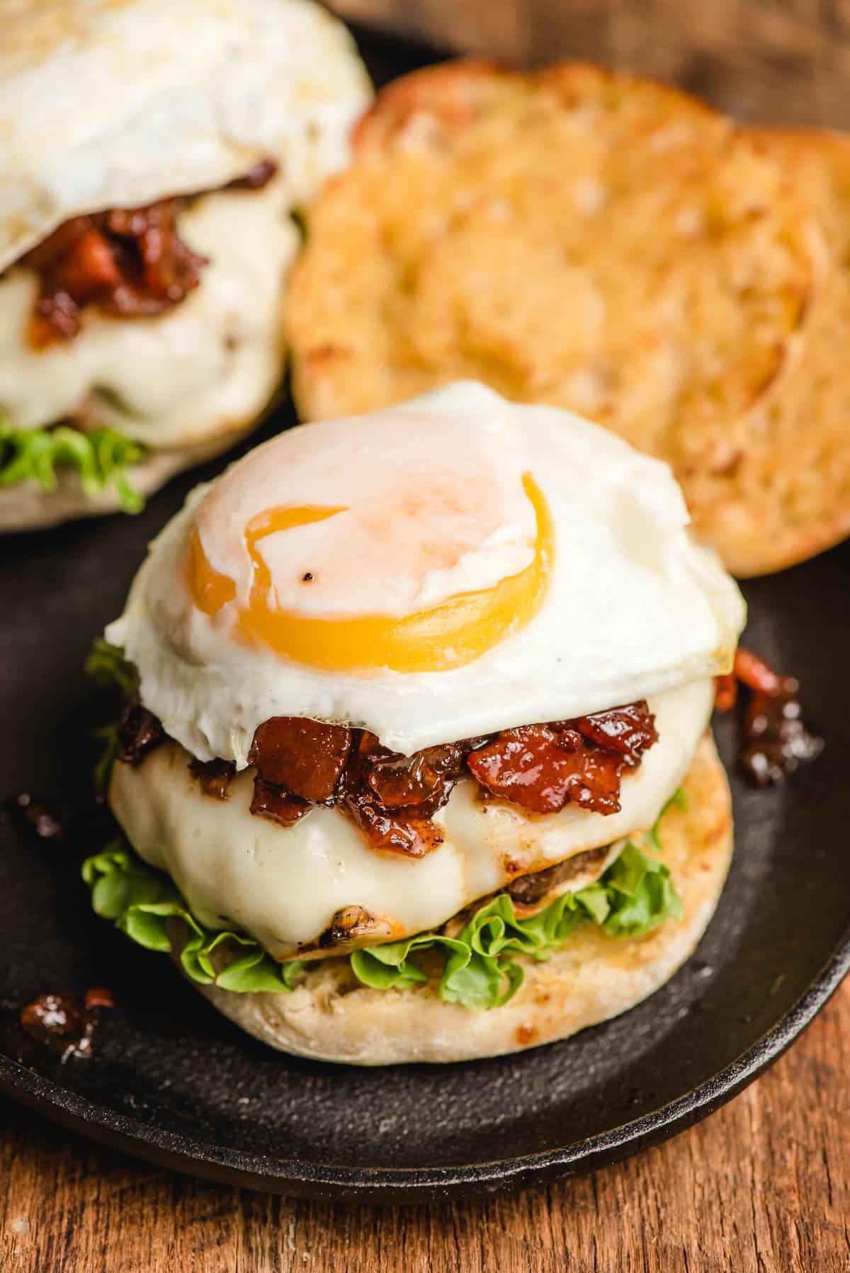 Fried egg burger with bacon jam and lettuce on an English muffin.
