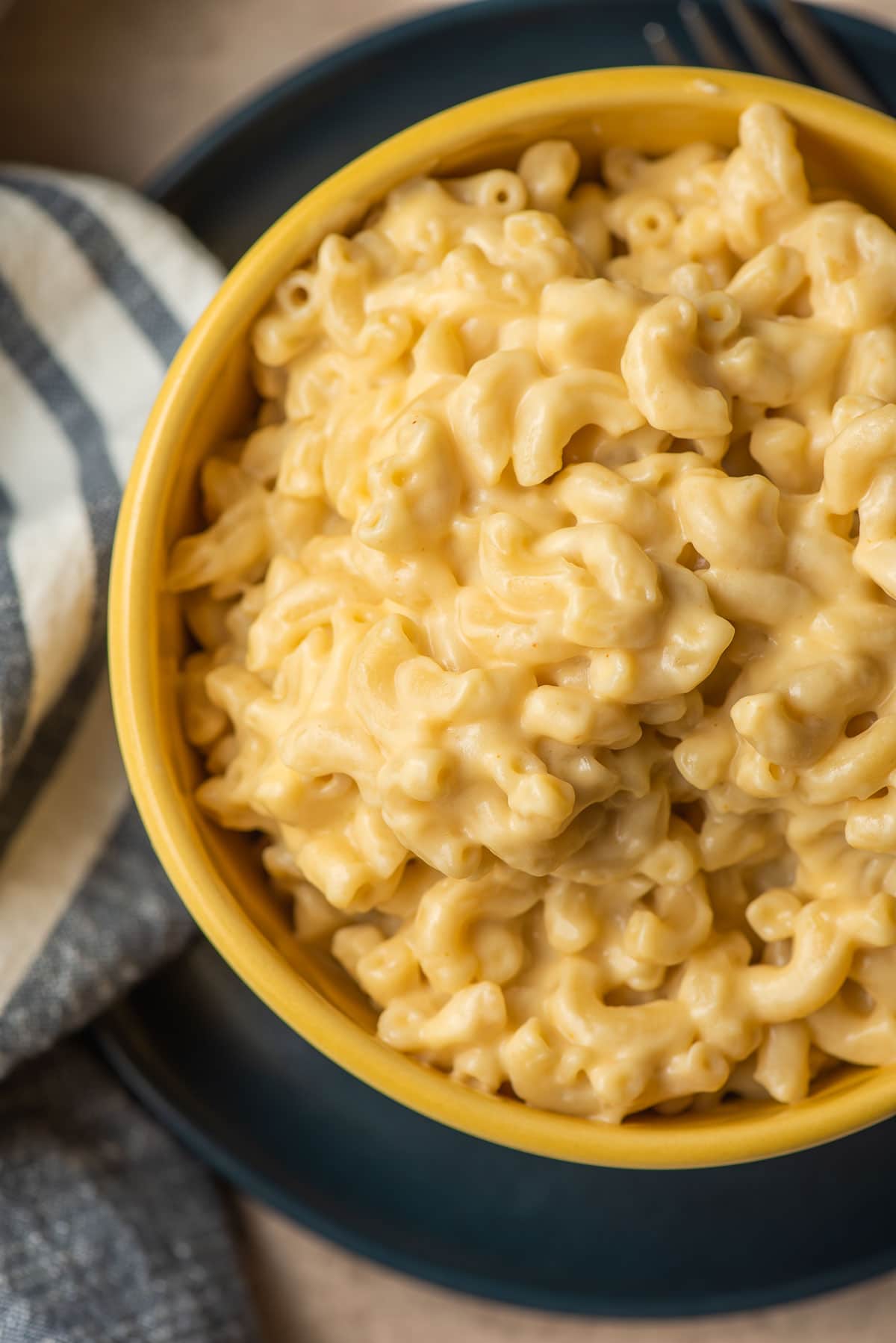 Yellow bowl filled with creamy mac and cheese.