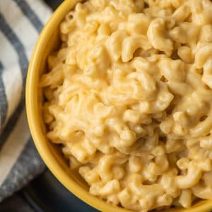 Yellow bowl filled with very creamy mac and cheese.