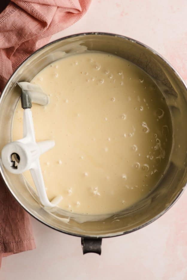 Yellow cake batter in the bowl of an electric mixer.