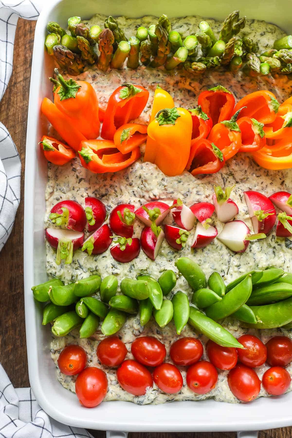 Overhead shot of veggies stuck in rows in dip to look like a garden. 