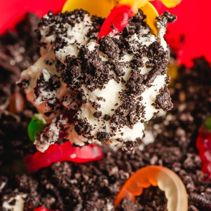 Sand shovel scooping up Oreo Dirt Cake with gummy worms.