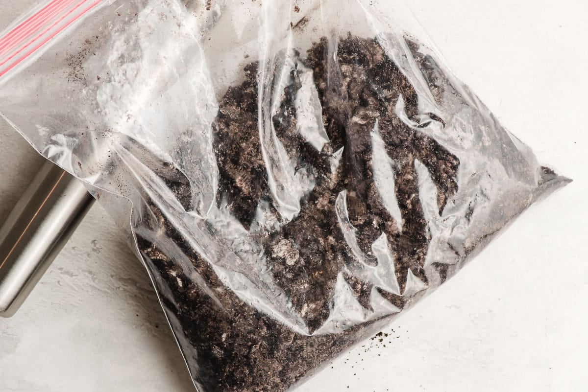 Crushed Oreos and butter in a ziplock bag.
