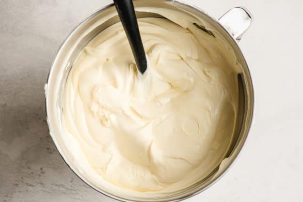 Fluffy pudding made with instant French vanilla pudding, Cool Whip, and cream cheese in the bowl of an electric mixer.