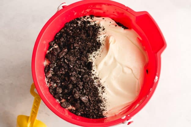 Red pail layered with vanilla pudding and Oreos.