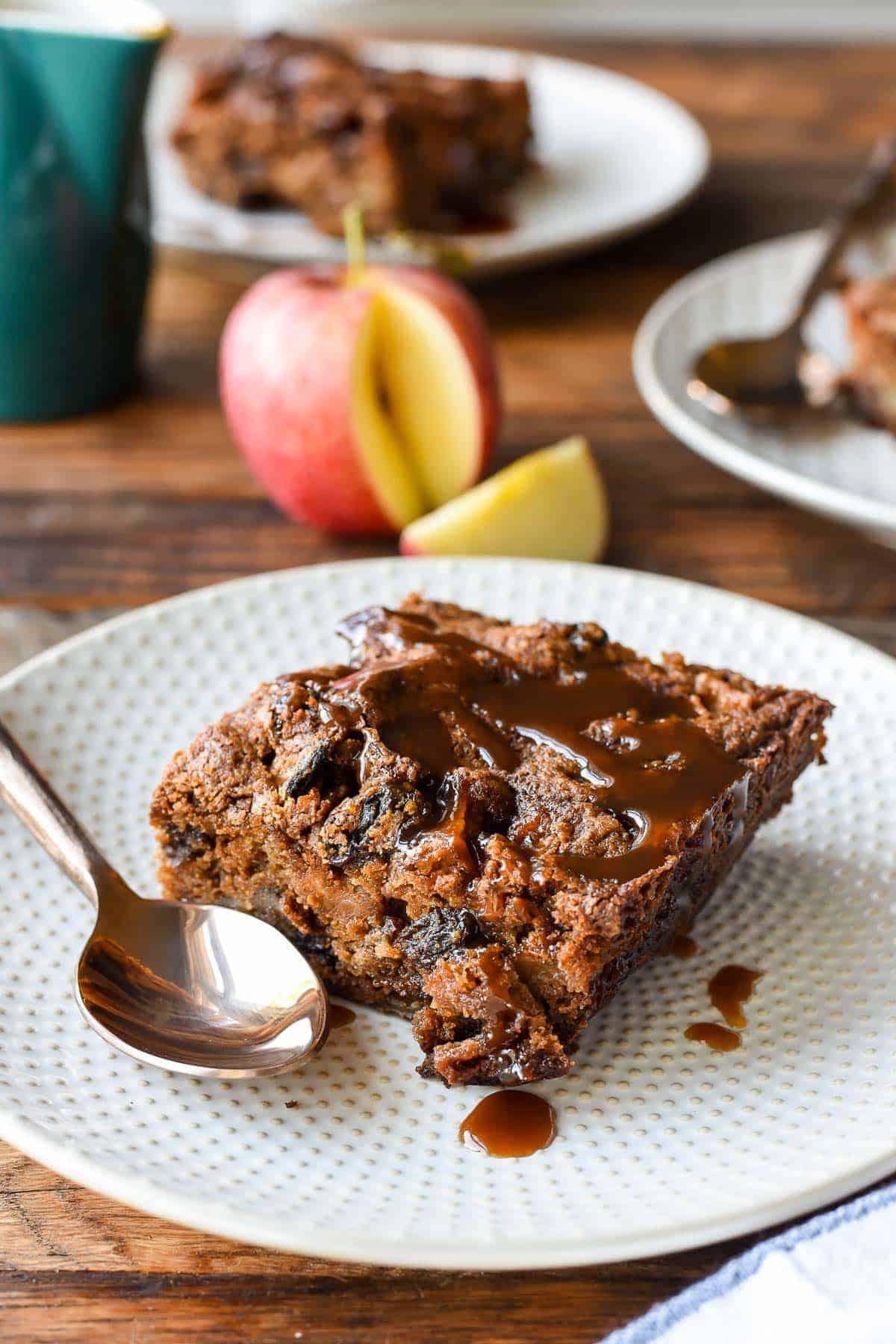 a sincle slice of spiced apple cake with caramel sauce on a plate